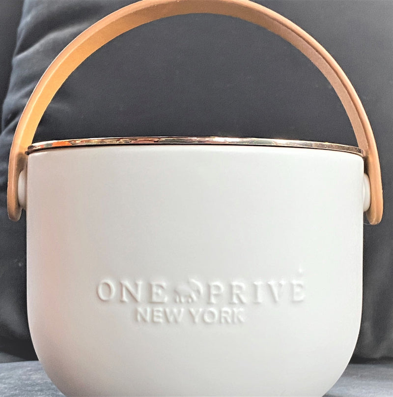 Indulge in the Bergamot and Clove Perfumed Estate Candle from One Preevay. Handcrafted with premium essential oils and soy wax, it features a stunning porcelain bowl with a silver-plated lid and leather strap. Elevate your ambiance with fine finishes