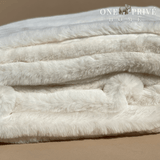  the One Preevay Faux Rabbit Fur Throw in Pure White. Inspired by the elegance of Fernando Botero and crafted from ultra-premium faux rabbit fur. Hypoallergenic, cruelty-free, over the sofa rolled 